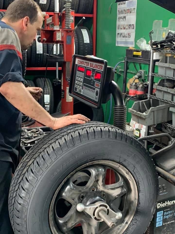 Finish Line technician balancing a tire on a computer wheel balancer in Livonia, MI